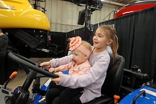 16012024
Seven-year-old Paisley Holden plays on a tractor with her sister Remi Poirier, one, during the opening day of Manitoba Ag Days 2024 at the Keystone Centre on Tuesday.
(Tim Smith/The Brandon Sun)