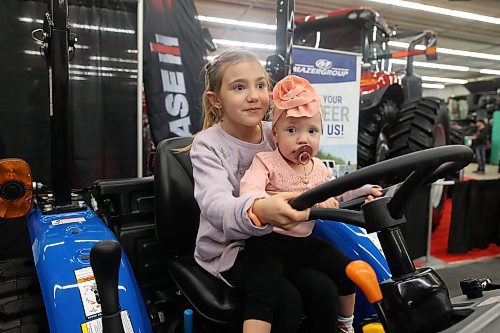 16012024
Seven-year-old Paisley Holden plays on a tractor with her sister Remi Poirier, 1, during the opening day of Manitoba Ag Days 2024 at the Keystone Centre on Tuesday.
(Tim Smith/The Brandon Sun)