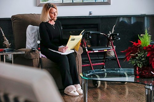 JOHN WOODS / WINNIPEG FREE PRESS
Cynthia Carr reads her post-op notes from Concordia Hip and Knee centre as she sits with her walker and cane in her home in Winnipeg Monday, January 16, 2024. Carr had a hip replaced on December 28/23 after a year of unrelenting pain. 

Reporter: ?