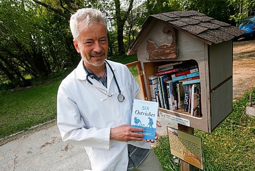 JOHN WOODS / WINNIPEG FREE PRESS
Philipp Schott, local author and veterinarian, is photographed with his new mystery novel, Six Ostriches, at his book exchange outside his home Tuesday, May 23, 2023. 

Reporter: sigurdson