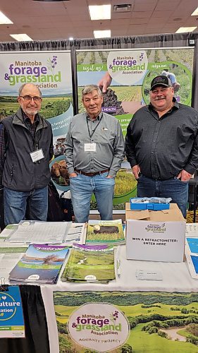 Jacques Saquet, a bison producer from the Ste. Rose du Lac area, Hans Rindlisbacher, a grassland and forage specialist, and Lawrence Knockaert, the chairperson of Manitoba Forage & Grassland Association, at the association's booth at Manitoba Ag Days at the Keystone Centre in Brandon on Wednesday, Jan. 17. (Miranda Leybourne/The Brandon Sun)