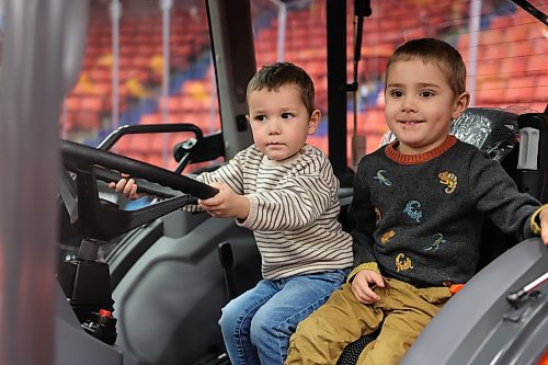 Matteo Naumann, 2, plays on a tractor with his brother Noah, 4, during the second day of Manitoba Ag Days at Brandon's Keystone Centre on Wednesday. (Abiola Odutola/The Brandon Sun)