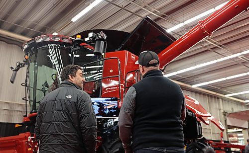 Sheldon Neufeld with Ens Quality Seed from Winkler, MB., listens to Chad Foster with Case IH as he talks about the features on the new Case IH combine at Manitoba Ag Days held in the Keystone Centre, which wrapped up on Thursday. (Michele McDougall/The Brandon Sun)