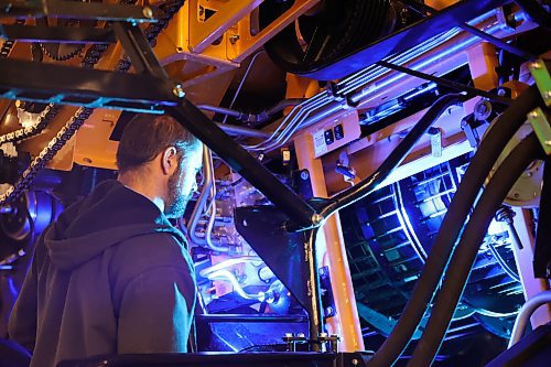 A man looks under the side panel of a New Holland combine at Manitoba Ag Days held in the Keystone Centre, which wrapped up on Thursday. (Michele McDougall/The Brandon Sun)
