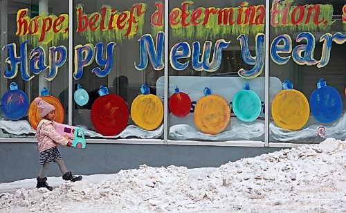 18012024
A young girl walks past a "Happy New Year" window mural outside Adult & Teen Challenge Super Thrift Brandon on Seventh Street on a cold Thursday. (Tim Smith/The Brandon Sun)