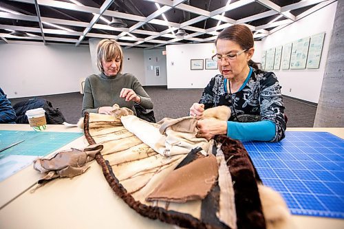 MIKAELA MACKENZIE / WINNIPEG FREE PRESS
	
Tracey Miller (left) and Beverley Findlay take apart a fur coat during a mitt making workshop at the Millennium Library ideaMILL on Thursday, Jan. 18, 2024. The mitts, which are made using re-purposed leather and fur coats, will be donated to an agency for community members in need.  Standup.
Winnipeg Free Press 2024