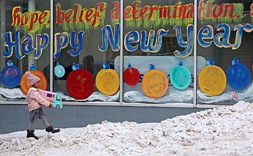 18012024
A young girl walks past a Happy New Year window mural outside Adult &amp; Teen Challenge Super Thrift Brandon on 7th Street on a cold Thursday. (Tim Smith/The Brandon Sun)