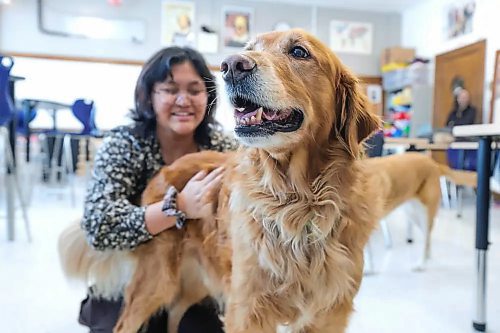 St. James Collegiate Grade 9 student, Kat Aseron, is all smiles as she pets Charlie, a canine trained in supporting students and staff with stress and behaviour challenges. Charlie is one of the division’s newest additions to its therapy-dog-in-residence program. (Ruth Bonneville/Winnipeg Free Press)