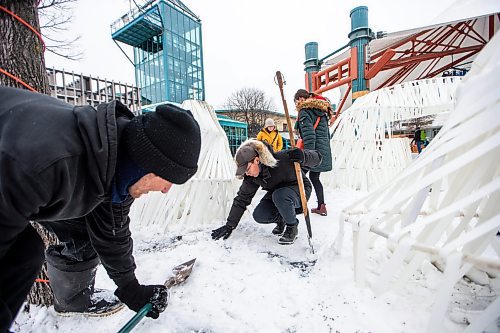 MIKAELA MACKENZIE / WINNIPEG FREE PRESS
	
Hayden Siemens (left) and architecture student Zhenggang Li make last-minute adjustments (protecting wires with rubber mats and snow) to the new 2024 warming hut Ice Henge, by the U of M architecture faculty, at The Forks on Friday, Jan. 26, 2024. For photo page.
Winnipeg Free Press 2024