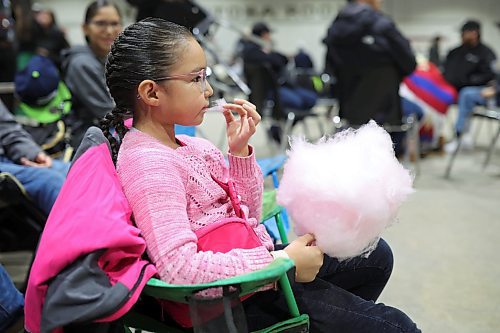 26012024
Six-year-old Lili Kaysaywaysemat enjoys some cotton candy while waiting for the Powwow Grand Entry to start at the Dakota Nation Winterfest at the Keystone Centre on Friday evening. The weekend-long Winterfest includes square dancing, Moccasin games, basketball, volleyball and a variety of other events.
(Tim Smith/The Brandon Sun)
