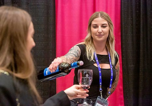 BROOK JONES / WINNIPEG FREE PRESS
Katie Peters (right) serves wine festival goer Madison Barker a glass of Malbec 2021 from from the Amalaya winery in Salta, Argentina during the public tastings at the Winnipeg Wine Festival at the RBC Convention Centre in Winnipeg, Man., Friday, Jan. 26, 2024. Internationals Cellars was hosting the Bodega Colom&#xe9; booth and serving the wine from the Amalaya winery.