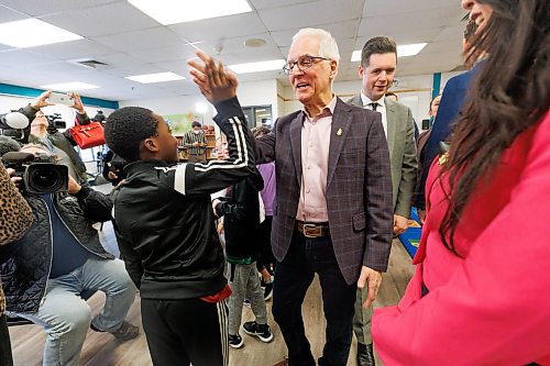 Grade 4 student, Elshadai Bukasa, 9, high-fives Education Minister Nello Altomare after he announces that the Manitoba government will increase operating funding for public schools by 3.4 per cent and support school divisions as they roll out a universal nutrition program, during a media conference at Joseph Teres School in Winnipeg on Thursday morning. (Mike Deal/Winnipeg Free Press)