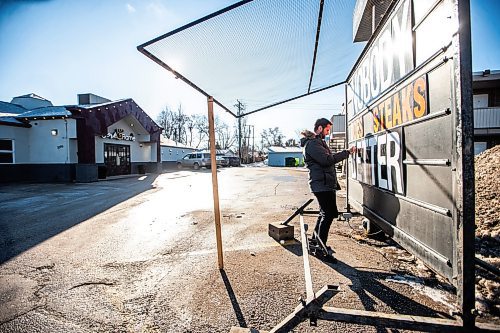 MIKAELA MACKENZIE / WINNIPEG FREE PRESS

Steven Karatasios puts the normal signage back up at the Cork and Flame on re-opening day on Friday, Feb. 2, 2024. For Chris Kitching story.
Winnipeg Free Press 2024.