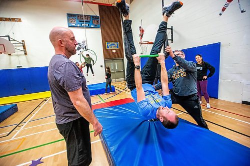 MIKAELA MACKENZIE / WINNIPEG FREE PRESS

Graham Forsyth tries out the trapeze with help from Dan Sarahs (left) and Chris Stradbrow during a circus arts professional development session at Heritage School on Friday, Feb. 2, 2024. For Maggie story.
Winnipeg Free Press 2024.