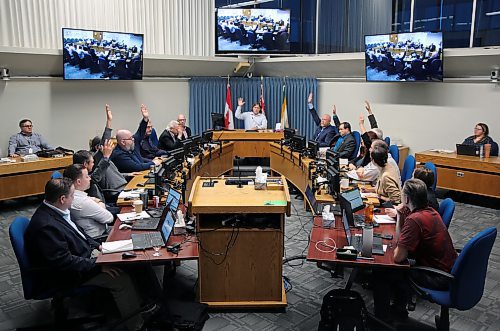 Members of Brandon City Council raise their hands late Saturday afternoon to approve a budget featuring a 9.4 per cent property tax increase as city staff look on. All but two councillors voted in favour of the final budget. (Colin Slark/The Brandon Sun)