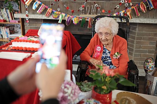 Longtime family friend Ricki Woods takes photos of 112-year-old Hazel Skuce as she celebrates her birthday with residents, staff and visitors at Hillcrest Place Personal Care Home in Brandon on Wednesday afternoon. (Tim Smith/The Brandon Sun)