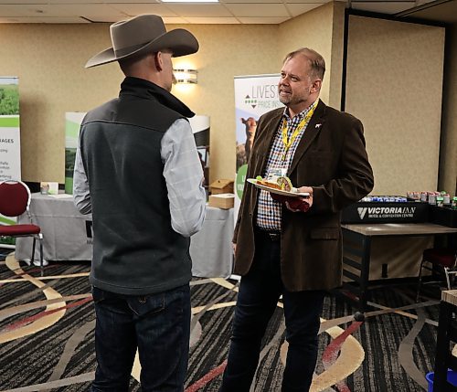 Canada Beef in-coming president Eric Bienvenue talks with Matthew Atkinson (left) - outgoing president of the Manitoba Beef Producers, during the annual general meeting of the Manitoba Beef Producers in Brandon's Victoria Inn on Thursday. (Michele McDougall/The Brandon Sun)
