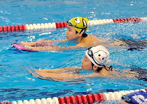 Brandon Bluefins brothers Jialin and Colin Li use flutter boards to work on their kicks during a Wednesday night practice in the Sportsplex pool. (Jules Xavier/The Brandon Sun)