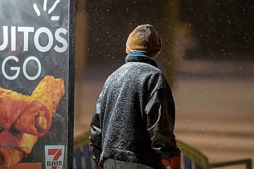 BROOK JONES / WINNIPEG FREE PRESS
Sixty-five-year-old Karl Waytiuk takes shelter from the wind and falling snow by standing next to an advertising sign for 7-Eleven while waiting for a Winnipeg Transit bus along St. Mary's Road in Winnipeg, Man., Thursday, Feb. 8, 2024.