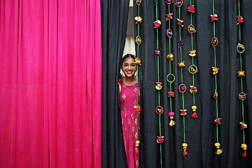 09022024
Milan Kaur peeks out from behind curtains while watching fellow performers dance at the India Pavilion in the Victoria Inn Imperial Ballroom during day two of the Westman Multicultural Festival on Friday evening. 
(Tim Smith/The Brandon Sun)