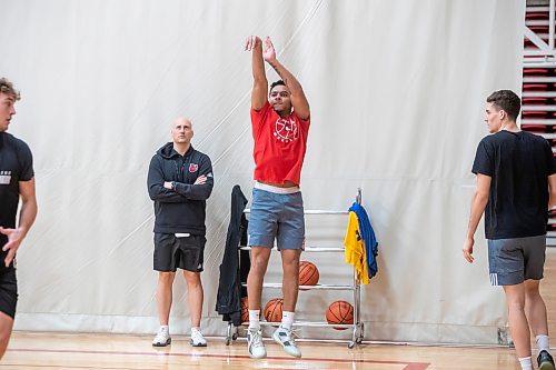 BROOK JOJNES / WINNIPEG FREE PRESS
University of Winnipeg Wesmen men's basketball team guard Malachi Alexander (red T-shirt), who graduated from &#xc9;cole Sisler High School, is pictured with his follow through after shooting a basketball while head coach Mike Raimbault (arms crossed) looks on during a practice at the Dr. David F. Anderson Gymnasium inside the Duckworth Centre at the University of Winnipeg in Winnipeg, Man., Tuesday, Feb. 13, 2024.