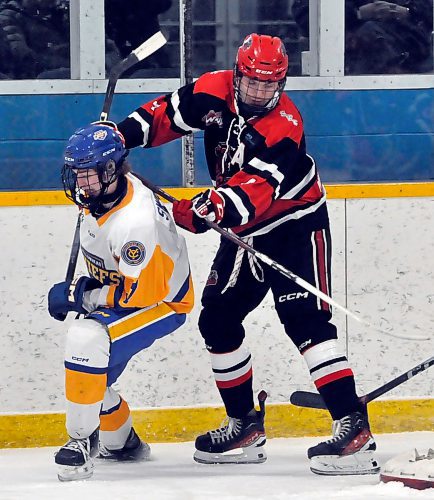 Second team all-star forward Regan Anderson (4) with the Southwest Cougars battles along the wall with a Yellowhead Chiefs opponent during a game in Shoal Lake last month. (Jules Xavier/The Brandon Sun)