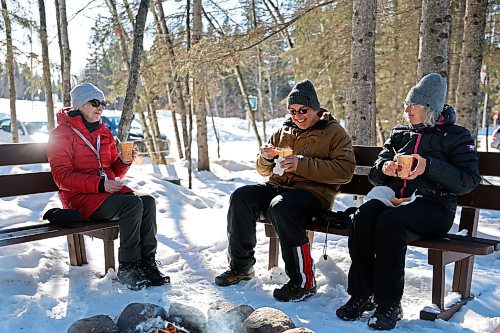 Visitors to the Friends of Riding Mountain National Park learning centre on Saturday enjoy cups of pea soup by a fire. (Colin Slark/The Brandon Sun)