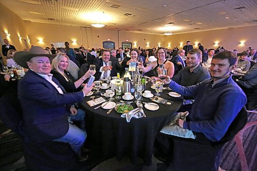 Provincial Exhibition of Manitoba general manager Mark Humphries (third from left) sits with members of his family, along with Heartland Livestock Services auctioneer Ward Culter (far left) and his wife, during the Provincial Exhibition of Manitoba's annual President's Dinner on Thursday evening at the Victoria Inn. (Matt Goerzen/The Brandon Sun)