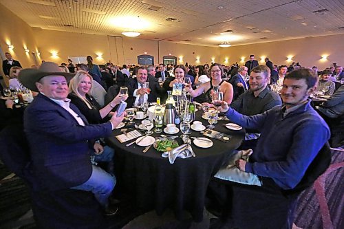 Provincial Exhibition of Manitoba general manager Mark Humphries, third from left, sits with members of his family, along with Heartland Livestock Services auctioneer Ward Culter, far left, and his wife, during the Provincial Exhibition of Manitoba's annual President's Dinner on Thursday evening at the Victoria Inn. (Matt Goerzen/The Brandon Sun)