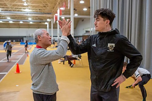 BROOK JONES / WINNIPEG FREE PRESS
University of Manitoba Bisons track &amp; field team assistant coach Mingpu Wu (left) and triple jump athlete Daxx Turner give each other a high five following a training session at the James Daly Fieldhouse at the University of Manitoba Fort Garry campus in Winnipeg, Man., Tuesday, Feb. 27, 2024. The Bisons men's team captured the Canada West Track &amp; Field Championships for the third year in a row.