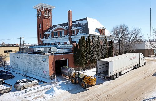 A forklift owned by Ben Wiebe Construction unloads brewing equipment into a garage on the north side of Brandon's historic fire hall on Princess Avenue. The firehall has been sold to new owners, who are storing the equipment there temporarily. (Matt Goerzen/The Brandon Sun)