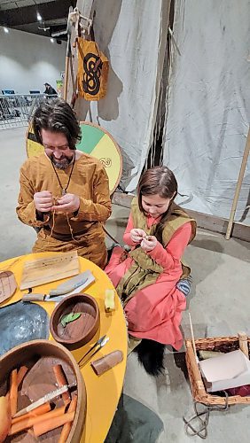 Viking re-enactor Joshua Corbin and his 10-year-old daughter Mara-Jade make historic crafts at the Westman Gaming Expo at the Keystone Centre on Saturday. (Miranda Leybourne/The Brandon Sun)