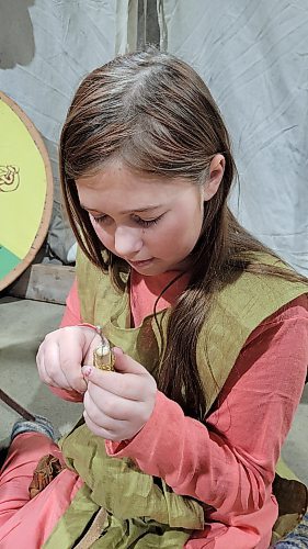 Mara-Jade Corbin, 10, works on a traditional craft at the Westman Gaming Expo at the Keystone Centre on Saturday, where her family, as part of the Markland Vikings, took part in historic re-enacting. (Miranda Leybourne/The Brandon Sun)