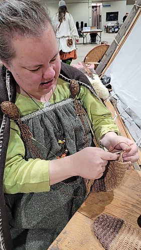 Alana Lindal, in Viking-era clothing, crochets at the Westman Gaming Expo at the Keystone Centre on Saturday. (Miranda Leybourne/The Brandon Sun)