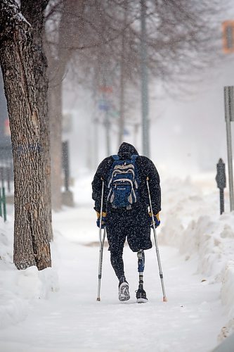 A pedestrian with a prosthetic leg walks down a snow-covered sidewalk on Princess Avenue with the help of a pair of crutches on Wednesday afternoon. (Matt Goerzen/The Brandon Sun)
