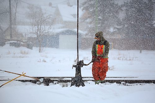 An employee with the Canadian National Railway cleans the tracks around a rail switch during Wednesday's snowstorm that dumped more snow on the region only days after a weekend blizzard. (Matt Goerzen/The Brandon Sun)