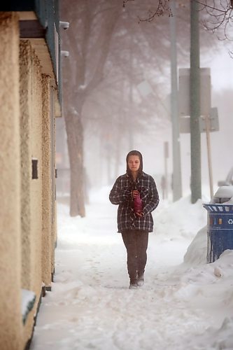A pedestrian walks down a snow-covered sidewalk along Princess Avenue on Wednesday afternoon. (Matt Goerzen/The Brandon Sun)