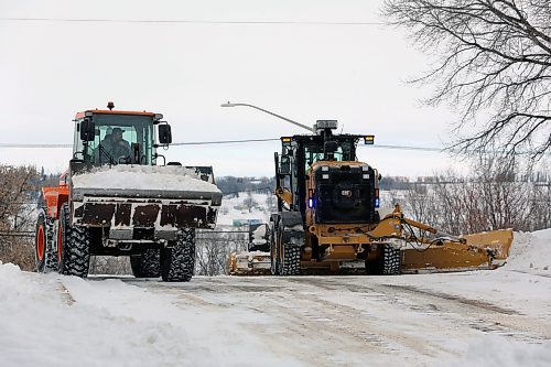 Machine operators with the City of Brandon work in tandem to clear an east-end intersection on Thursday afternoon. City staff were still dealing with snow dropped by last weekend's blizzard when 16 more centimetres of snow fell Wednesday night and Thursday morning. (Colin Slark/The Brandon Sun)
