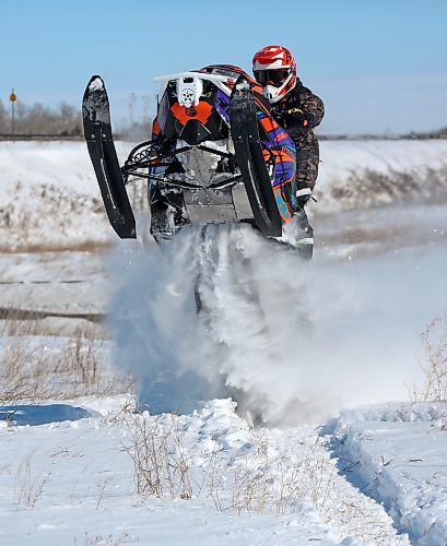 One of a pair of snowmobilers gets some air from a snowdrift along the ditch near Highway 110 under blue skies on a sunny Friday afternoon. (Matt Goerzen/The Brandon Sun)