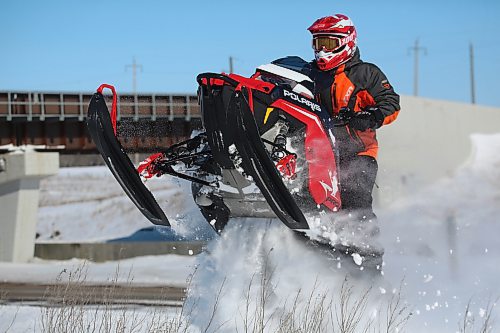 One of a pair of snowmobilers gets some air from a snowdrift along the ditch near Highway 110 under blue skies on a sunny Friday afternoon. (Matt Goerzen/The Brandon Sun)