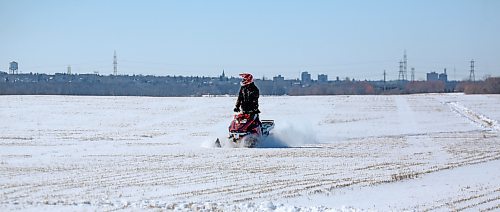 A snowmobiler takes advantage of the recent snow in western Manitoba, enjoying a clear blue sky on Friday afternoon, with the Brandon skyline behind him, east of the city. (Matt Goerzen/The Brandon Sun)
