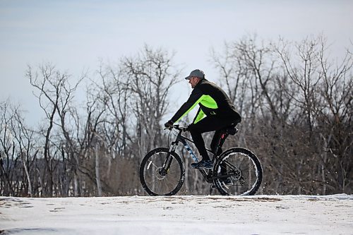 A cyclist enjoys a warm March afternoon along a snowy riverbank on Kirkcaldy Drive on Monday afternoon. (Matt Goerzen/The Brandon Sun)
