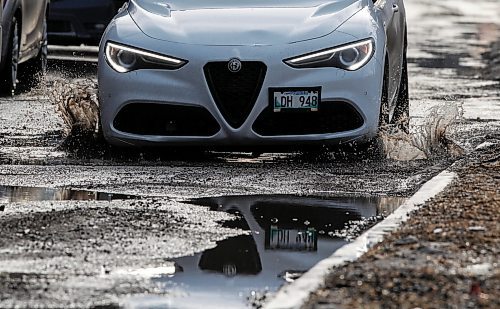 JOHN WOODS / FREE PRESS
Driver hits a  submerged potholes on Stradbrook Monday, March 11, 2024. 

Reporter: ?