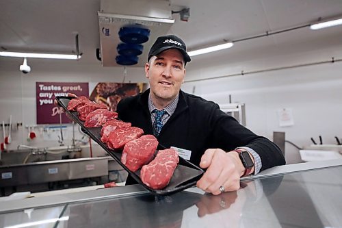 Franchise owner Greg Gingras holds up a display of steaks behind the newly renovated butcher's counter at Sobeys West in Brandon. (Matt Goerzen/The Brandon Sun)