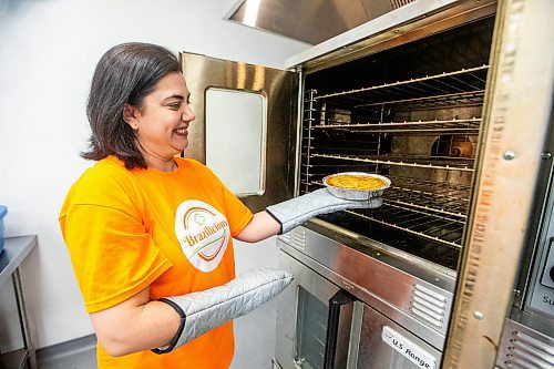 MIKAELA MACKENZIE / FREE PRESS

Marli Cordella, c0-owner of Brazilicious, takes a chicken pie out of the oven in their commercial kitchen in Winnipeg on Wednesday, March 13, 2024.  

For Dave Sanderson story.