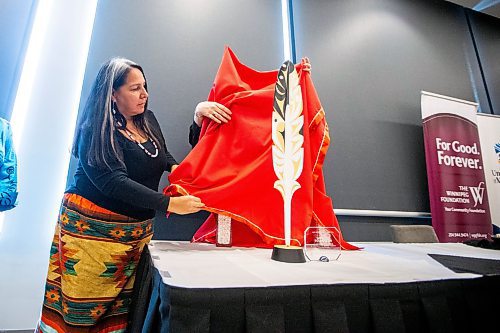 MIKAELA MACKENZIE / FREE PRESS

National Centre for Truth and Reconciliation executive director Stephanie Scott unveils an eagle feather carving gift after five million in funding was announced from the Winnipeg Foundation in Winnipeg on Thursday, March 14, 2024.  

For Malak story.