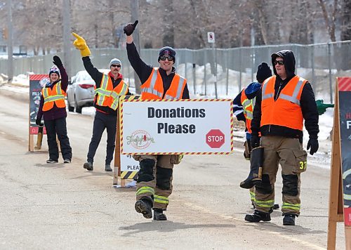 Fundraising members of Brandon Fire & Emergency Services wave donation signs and flag down passing motorists outside Brandon First Station 2 on 13th Street on Friday afternoon to help raise money for the last day of the Brandon Firefighters Tri-Charity Rooftop Campout and Boot Drive. See story on page A3. (Matt Goerzen/The Brandon Sun)