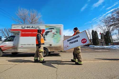 A moving truck passes members of Brandon Fire & Emergency Services outside Brandon Fire Station 2 on 13th Street on Friday afternoon, during the last day of the Brandon Firefighters Tri-Charity Rooftop Campout and Boot Drive. (Matt Goerzen/The Brandon Sun)