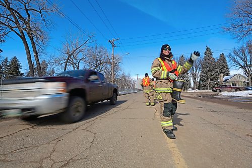 A truck passes behind Sarah Peto with the Brandon Fire & Emergency Services while fundraising outside Brandon Fire Station 2 on 13th Street on Friday afternoon. (Matt Goerzen/The Brandon Sun)