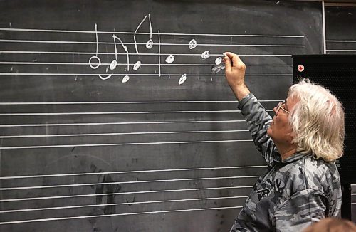 Brandon University Prof. Edward Bach, an accomplished trumpeter and master musical clinician, writes notes down on a chalk board in a room full of high school students who have come to hear him lead a trumpet masterclass on Friday afternoon, as part of BU's three-day Jazz Festival. (Matt Goerzen/The Brandon Sun)